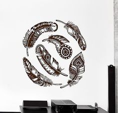 an artistic wall decal with feathers in the shape of a circle on top of a desk