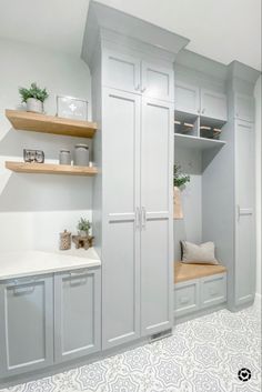 a kitchen with white cabinets and wooden shelves