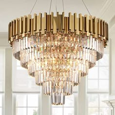 a large chandelier hanging from the ceiling in a room with windows and furniture