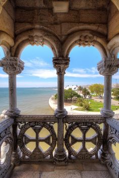 an ornate balcony overlooks the ocean and beach