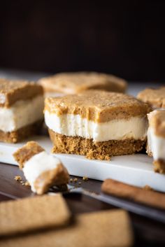 several pieces of dessert sitting on top of a white plate next to graham crackers