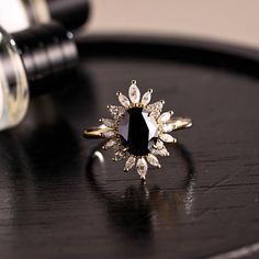 a black diamond ring sitting on top of a wooden table