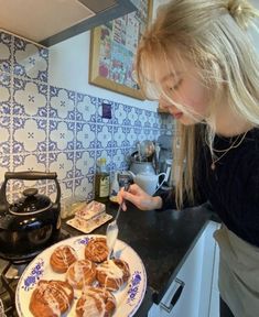 a woman standing in front of a plate of food on top of a kitchen counter