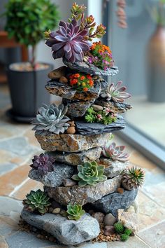 a stack of rocks with succulents on top