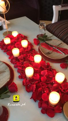 the table is set with candles and rose petals