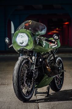 a green motorcycle parked on top of a parking lot