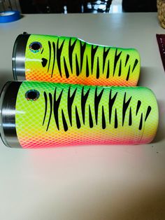 two green and yellow lighters sitting on top of a white table next to each other