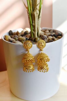 "Mid Sized Statement South Indian Style Jhumka Earrings 16kt Gold over brass 2.5\" L x 0.7\" W Post and backing" Festive Brass Jhumkas, Festival Brass Drop Jhumkas, Gold-plated Jhumkas For Festivals, Gold Plated Jhumka For Festivals, Gold Bollywood Dangle Jhumkas, Gold Bollywood Style Dangle Jhumkas, Gold Jhumkas With Tilla For Navratri, Gold Jhumkas For Navratri Puja, Bollywood Style Gold Dangle Jhumkas