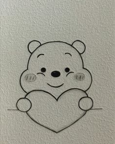 a drawing of a teddy bear holding a heart on a white paper with black outline