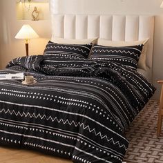 a bed with black and white bedspread in a bedroom