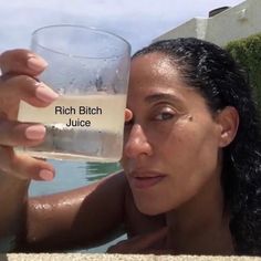 a woman holding up a wine glass in front of her face with the words mind my business juice written on it