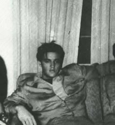 black and white photograph of two men sitting on a couch