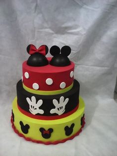 a three tiered cake with mickey and minnie mouse decorations