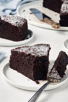 three plates with slices of chocolate cake on them and one slice has been cut from it