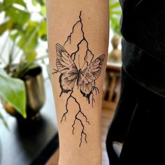 a woman's arm with a butterfly and lightning tattoo on the left side of her leg