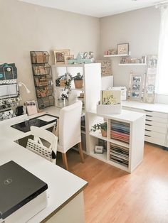 an office with white desks and shelves filled with papers on top of each other