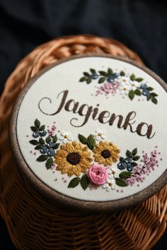 a wooden box with embroidered flowers and the word jagenka on it in front of a black background