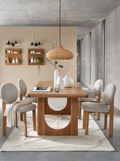 a dining room table with chairs and a rug on the floor in front of it