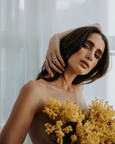 a woman holding a bouquet of yellow flowers