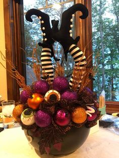 a vase filled with ornaments on top of a table next to a window sill