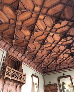 an ornate wooden ceiling in a room with pictures on the wall and paintings on the walls