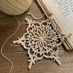 a crocheted doily sits next to an open book