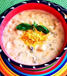 a bowl of soup with cheese and spinach on top