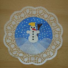 a paper doily with a snowman on it