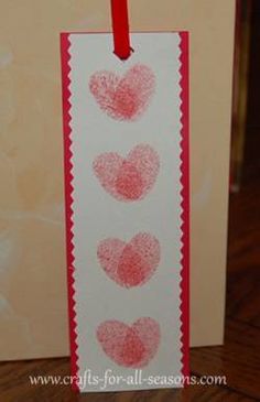 a card with three hearts drawn on it and a red string hanging from the front