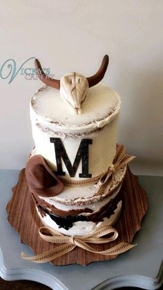 a three tiered cake with the letter m on it's side and an animal head