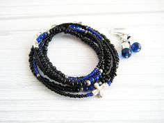 wrap bracelet and earring set/ black, dark blue, and silver glass beads with a silver-plated cross/ made with coated wire and a lobster clasp/ adjustable/ fits 6.5-7.5 inch wrist/ convertible/ can also be worn as a necklace/ includes coordinating earrings/ option to buy bracelet only more bracelet and earring sets: https://www.etsy.com/shop/CabanaCraftroom?search_query=set&page=1#items Bracelet And Earring Set, Faith Jewelry, Earring Sets, Silver Glass, Dark Black, Blue And Silver, Wrap Bracelet, Lobster Clasp, Earring Set