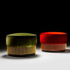 two velvet stools with gold trim on the sides and one in red, yellow and green