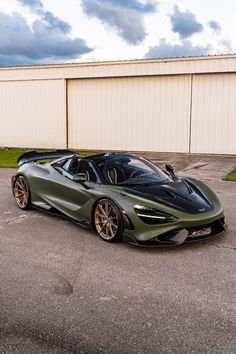 a green sports car parked in front of a building