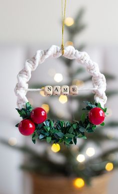 a christmas ornament hanging from a tree with the name namb spelled on it