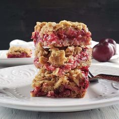 three dessert bars stacked on top of each other with cherries in the back ground