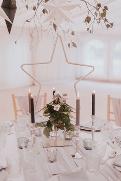 a table with candles and flowers on it in front of a star shaped centerpiece