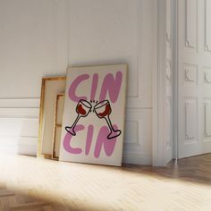 a pink gin sign sitting on top of a wooden floor next to an empty frame