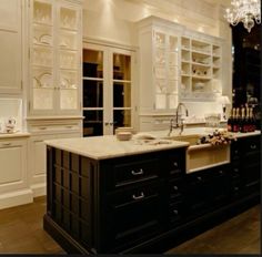 a large kitchen with white cabinets and marble counter tops