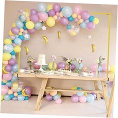 a table topped with balloons and cake next to a wall