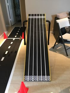 a black and white race track set up in the living room with two chairs around it