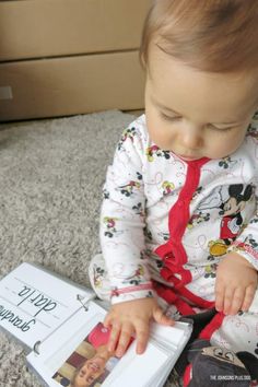 a baby sitting on the floor playing with a book