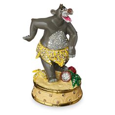 a figurine of an elephant wearing a skirt and holding a christmas ornament