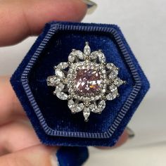 a ring that is in a blue velvet box with some diamonds on the inside and outside