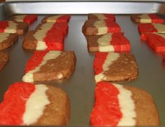 red and white desserts are lined up on a baking sheet, ready to go into the oven