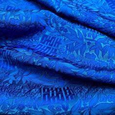 a blue fabric with an intricate design on the top and bottom half, in shades of blue