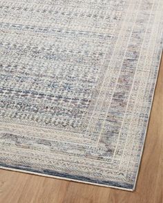 a blue and white area rug on a wooden floor with wood floors in the background