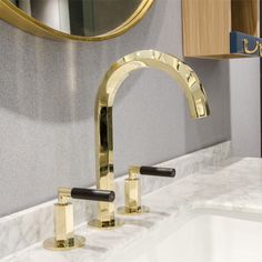 a bathroom sink with two faucets and a mirror