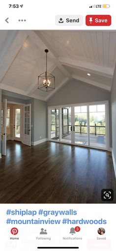 an empty living room with hard wood flooring and white painted walls, large open windows