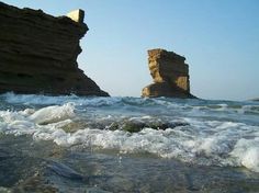 waves crashing on the beach and rocks in the background