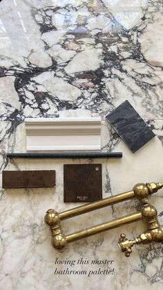 marble counter top with brass faucets and paint samples